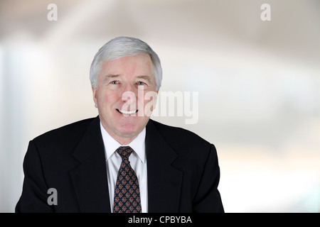 Senior business man in tuta blu sorridente in ufficio Foto Stock