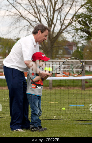 Bambino di essere insegnato come giocare a tennis, Newmarket Festival dello Sport, Suffolk REGNO UNITO Foto Stock