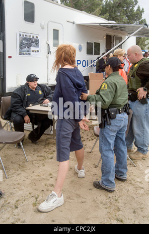 Sheriff's deputati arrestare un senzatetto donna su un eccezionale garantisce in Victorville, CA, durante la ricerca di un accampamento. Foto Stock
