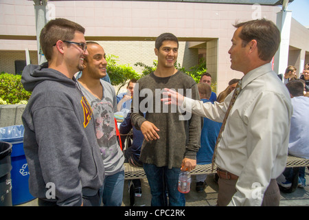 Una scuola superiore principale colloqui con tre senior maschili degli studenti del campus suburbana a pranzo in Aliso Viejo, CA. Foto Stock