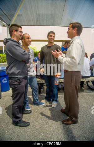 Una scuola superiore principale colloqui con tre senior maschili degli studenti del campus suburbana a pranzo in Aliso Viejo, CA. Foto Stock