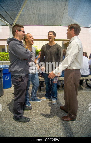 Una scuola superiore principale colloqui con tre senior maschili degli studenti del campus suburbana a pranzo in Aliso Viejo, CA. Foto Stock