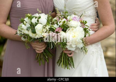 Sposa e damigella azienda floreale bouquet di nozze Foto Stock