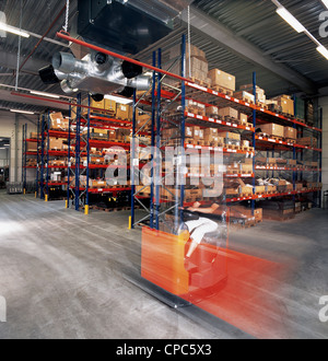 Lavoratore di magazzino driver con il carrello elevatore in magazzino Foto Stock