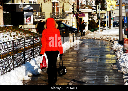 La donna in un ponticello rosso camminando per le strade di Ginevra, Svizzera Foto Stock