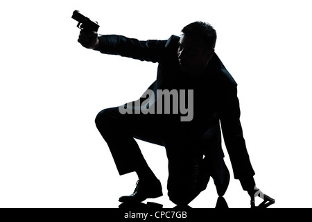 Una spy caucasica poliziotto penale detective uomo che ha di mira la pistola di scatto a piena lunghezza silhouette in studio isolato sfondo bianco Foto Stock