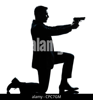 Una spy caucasica poliziotto penale detective uomo che ha di mira la pistola di scatto a piena lunghezza silhouette in studio isolato sfondo bianco Foto Stock