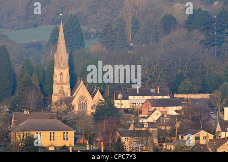 La Chiesa Parrocchiale di Santa Maria e case di villaggio in inizio di mattina di luce, Woodchester, Gloucestershire, Cotswolds, REGNO UNITO Foto Stock