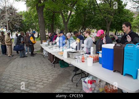 Detroit, Michigan - Volontari feed senzatetto da tabelle configurate nel Parco Cass. Foto Stock