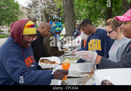 Detroit, Michigan - Volontari feed senzatetto da tabelle configurate nel Parco Cass. Foto Stock