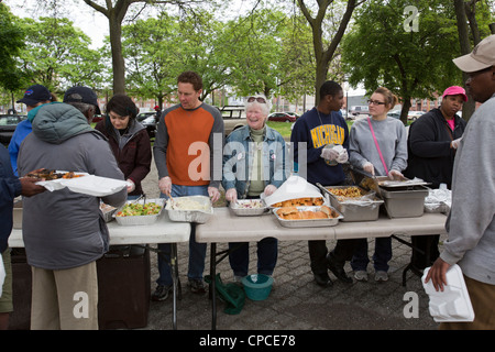 Detroit, Michigan - Volontari feed senzatetto da tabelle configurate nel Parco Cass. Foto Stock