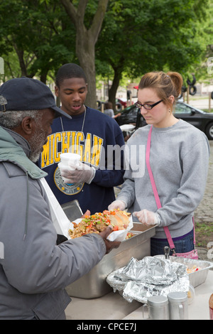 Detroit, Michigan - Volontari feed senzatetto da tabelle configurate nel Parco Cass. Foto Stock