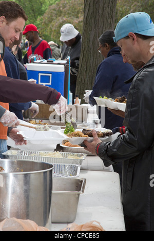 Detroit, Michigan - Volontari feed senzatetto da tabelle configurate nel Parco Cass. Foto Stock