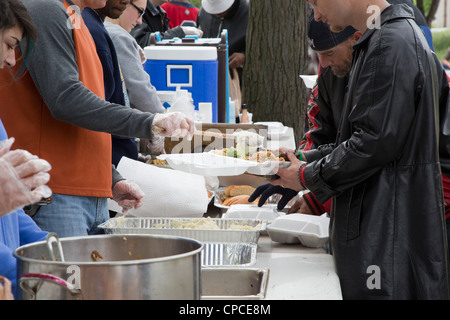 Detroit, Michigan - Volontari feed senzatetto da tabelle configurate nel Parco Cass. Foto Stock