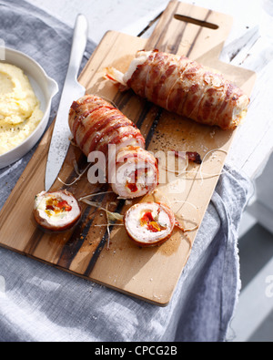 Involtini di pollo su pannello di legno Foto Stock