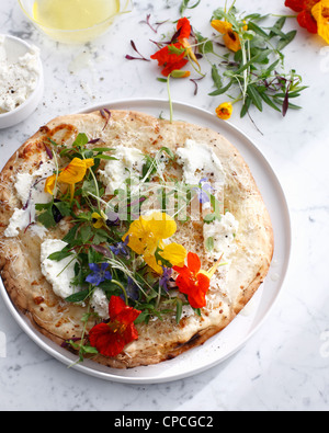 Piastra di pizza con formaggio e fiori Foto Stock