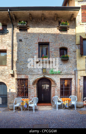 Orientata in verticale immagine della vecchia casa con bar al primo piano nella città di Sirmione, Italia settentrionale. Foto Stock