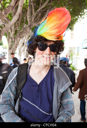 Un giovane maschio caucasico indossando una parrucca arcobaleno Foto Stock