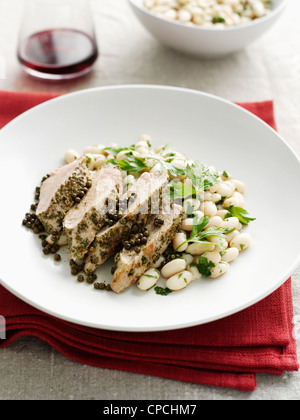 Piatto di pollo con capperi e fagioli Foto Stock