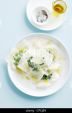 Chiudere la vista di un serving di cotte conserve di ravioli in un  recipiente rosso con un cucchiaio Foto stock - Alamy