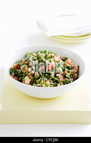 Ciotola di tabouli con erbe e pomodori Foto Stock