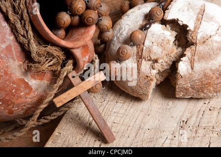 Antiquariato brocca vino, rosario e rustico della pagnotta di pane come simboli cristiani della fede Foto Stock