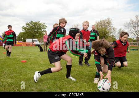 Bambino junior giocando a rugby e con un punteggio provare, Newmarket Juniors, Suffolk REGNO UNITO Foto Stock