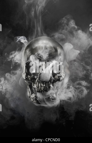 Il fumo versando dal cranio di metallo Foto Stock