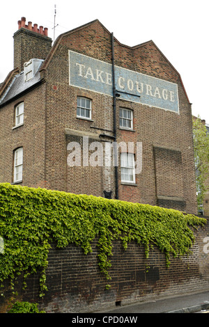 Dipinto 'prendere coraggio' birra pubblicità sul lato dell'edificio, London, Regno Unito Foto Stock