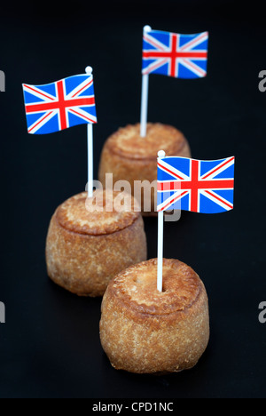 British pasticci di carne di maiale con union jack flag su sfondo nero Foto Stock