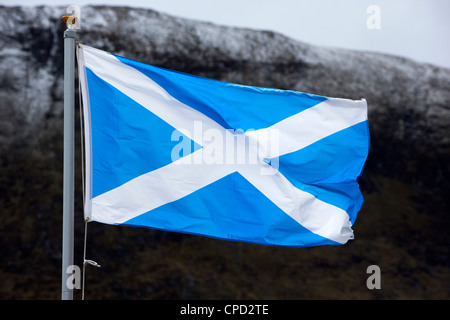 Scottish si intraversa croce di Sant' Andrea bandiera nazionale battenti nelle highlands con montagne innevate Scotland Regno Unito Foto Stock