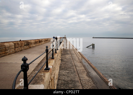 Giovane camminando sul molo nord a Tynemouth, North Tyneside, Tyne and Wear, England, Regno Unito, Europa Foto Stock