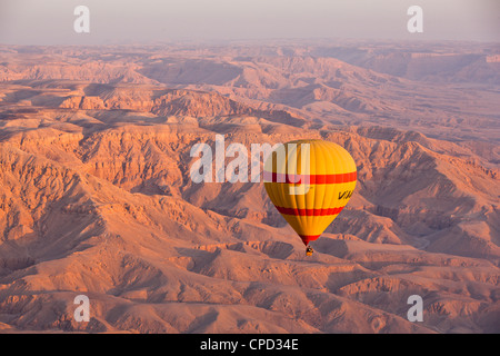 Una mongolfiera sospesa sopra le colline tebana di Luxor all'alba, Tebe, Egitto, Africa Settentrionale, Africa Foto Stock