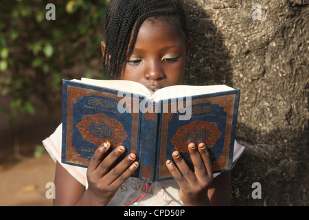 Ragazza giovane la lettura del Corano, Lomé, Togo, Africa occidentale, Africa Foto Stock