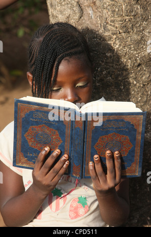 Ragazza giovane la lettura del Corano, Lomé, Togo, Africa occidentale, Africa Foto Stock