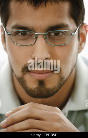 Close up di uomo con barba indossando occhiali da vista Foto Stock