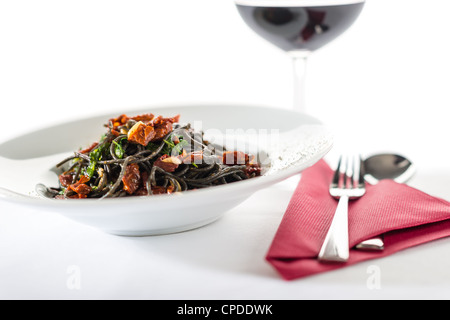 Stile Italiano spaghetti con pomodori secchi, aglio su sfondo bianco Foto Stock