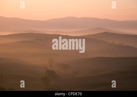 Un alba vista sulle misty colline della Val d'Orcia, Sito Patrimonio Mondiale dell'UNESCO, Toscana, Italia, Europa Foto Stock