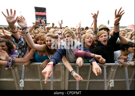 La folla in prima fila urlando a un concerto di musica Foto Stock
