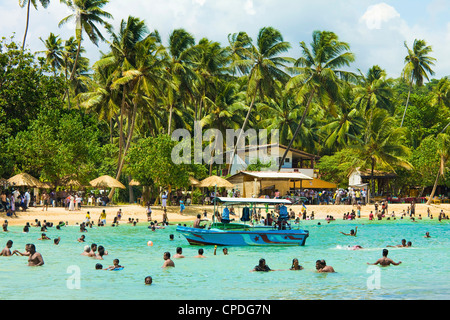 Gli abitanti dello Sri Lanka il nuoto presso il west end di questa popolare resort e la spiaggia, devastata dallo tsunami, Unawatuna, Galle, Sri Lanka Foto Stock