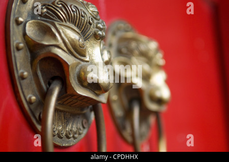 Lion maniglie sagomate sul gate di un hutong di Pechino, Cina Foto Stock