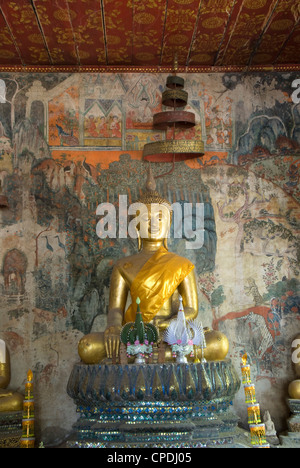 Seduto statua del Buddha con murali in background, Wat Pak Huak, Luang Prabang, Laos, Indocina, Asia sud-orientale, Asia Foto Stock