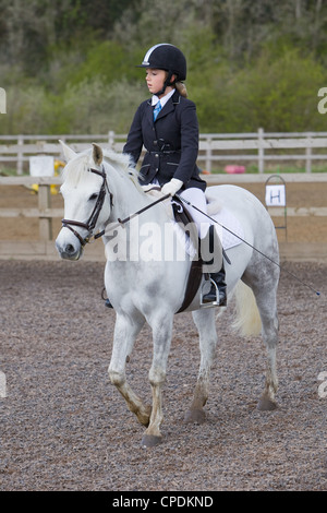 Un cavallo e cavaliere competere in un evento di dressage detenute al di fuori su di una spiaggia di sabbia e gomma in corso Inghilterra Foto Stock