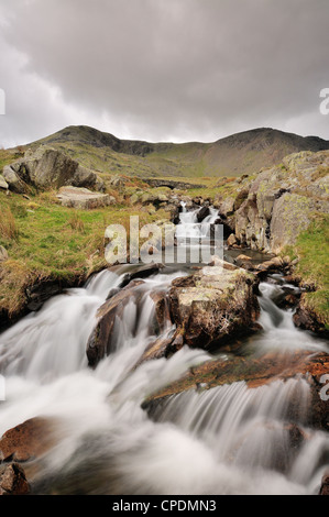 Torver Beck e ponte al di sopra della cicatrice Walna Road nel Lake District inglese, Marrone Pike e Buck Pike in background Foto Stock