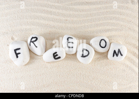Libertà parola sul gruppo di pietre con Sfondo sabbia Foto Stock