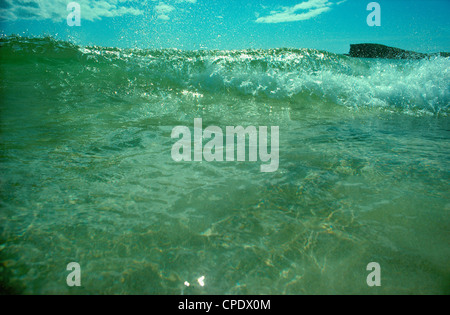 Vola a spruzzo dalla sommità di onda verde sbarcano a Oldshoremore Bay nei pressi di Kinlochbervie, Sutherland, Scozia settentrionale Foto Stock