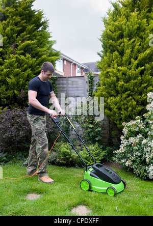 Uomo caucasico la falciatura di prato in giardino a Bristol, Regno Unito Foto Stock