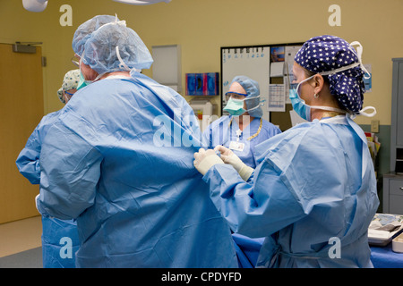 Chirurgo ortopedico preparazione paziente per artroscopica chirurgia del ginocchio in un ospedale in sala operatoria suite Foto Stock