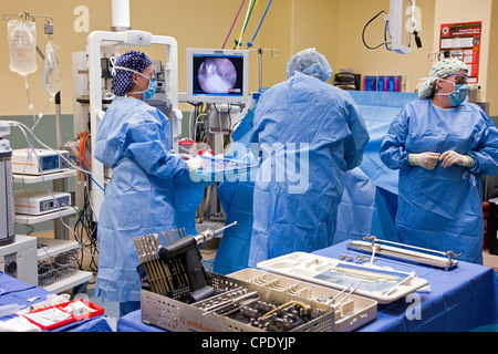 Chirurgo ortopedico preparazione paziente per artroscopica chirurgia del ginocchio in un ospedale in sala operatoria suite Foto Stock