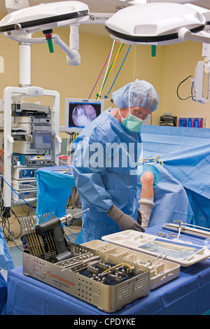 Chirurgo ortopedico preparazione paziente per artroscopica chirurgia del ginocchio in un ospedale in sala operatoria suite Foto Stock